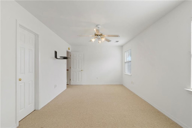 empty room with light carpet, baseboards, visible vents, and a ceiling fan