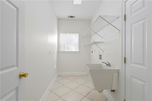 laundry area featuring laundry area, light tile patterned floors, visible vents, hookup for a washing machine, and a sink