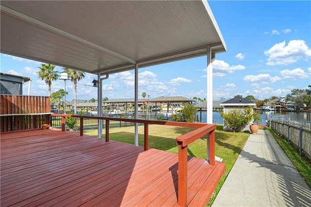 wooden terrace with a water view and a yard