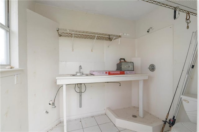 laundry room with light tile patterned floors and a sink