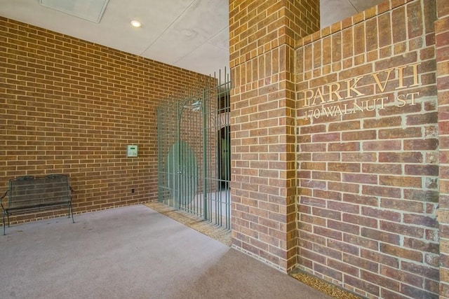 hallway with brick wall and carpet flooring