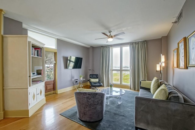 living room featuring ceiling fan and light hardwood / wood-style flooring