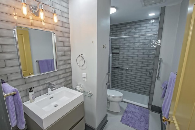 bathroom with vanity, toilet, a shower with door, and decorative backsplash