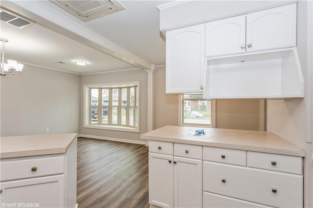 kitchen featuring crown molding, dark wood-type flooring, hanging light fixtures, white cabinets, and a chandelier