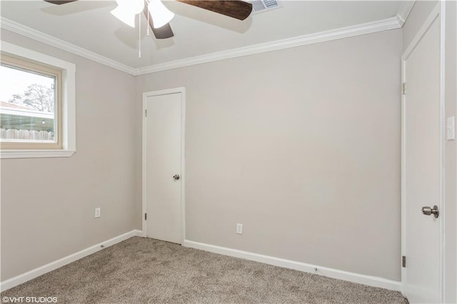 carpeted spare room featuring crown molding and ceiling fan