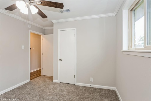 unfurnished bedroom with crown molding, light colored carpet, and ceiling fan