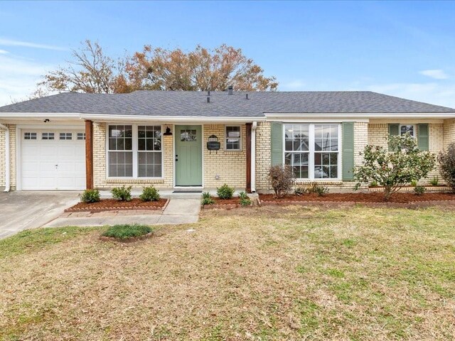 ranch-style house featuring a garage and a front lawn