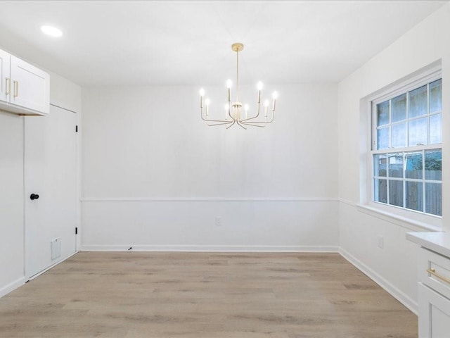 unfurnished dining area featuring a notable chandelier and light wood-type flooring