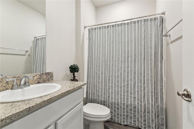 full bathroom featuring vanity, hardwood / wood-style floors, shower / tub combo, and toilet