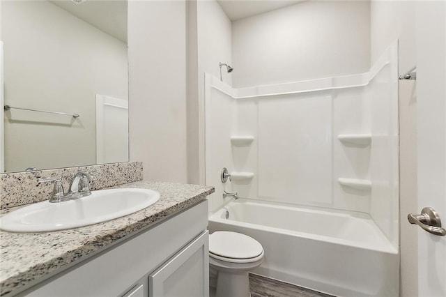 full bathroom with vanity, wood-type flooring, washtub / shower combination, and toilet