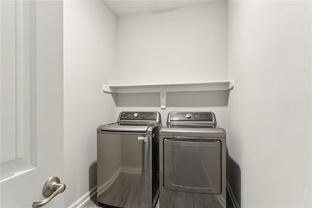 laundry room featuring washing machine and dryer and hardwood / wood-style floors