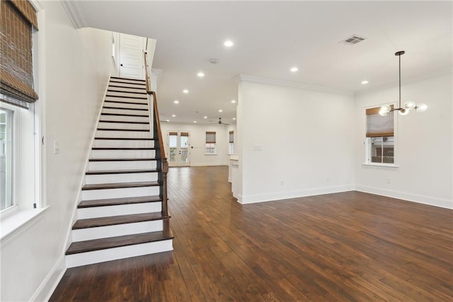 staircase featuring a notable chandelier, crown molding, and wood-type flooring