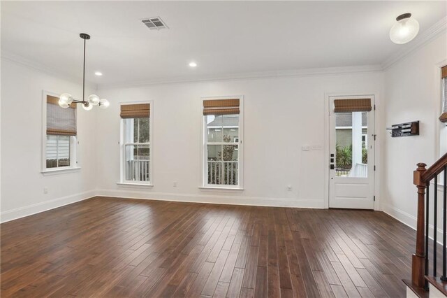 interior space with ornamental molding, an inviting chandelier, and dark hardwood / wood-style flooring