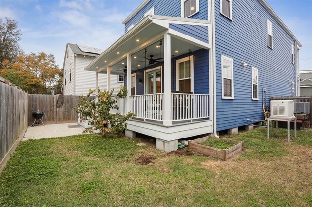 rear view of house featuring a patio, covered porch, ceiling fan, and a lawn