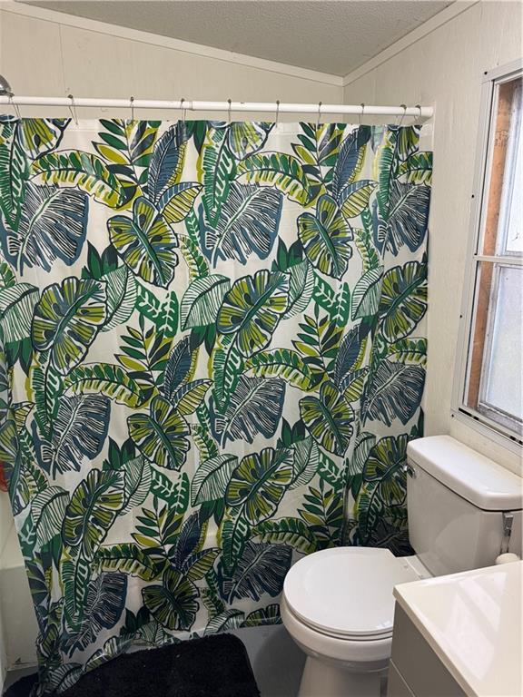 bathroom featuring lofted ceiling, curtained shower, a textured ceiling, and toilet