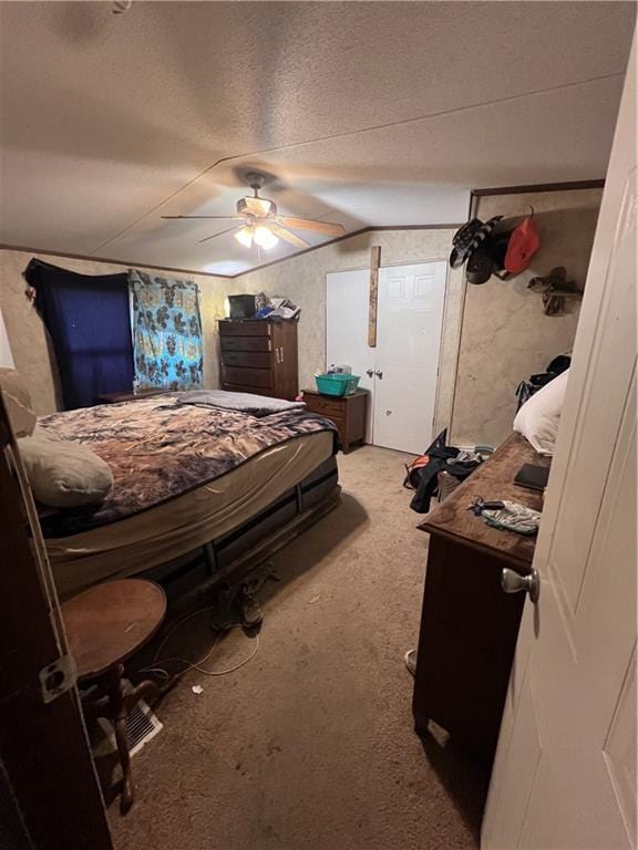 bedroom featuring a textured ceiling, carpet floors, ceiling fan, and vaulted ceiling