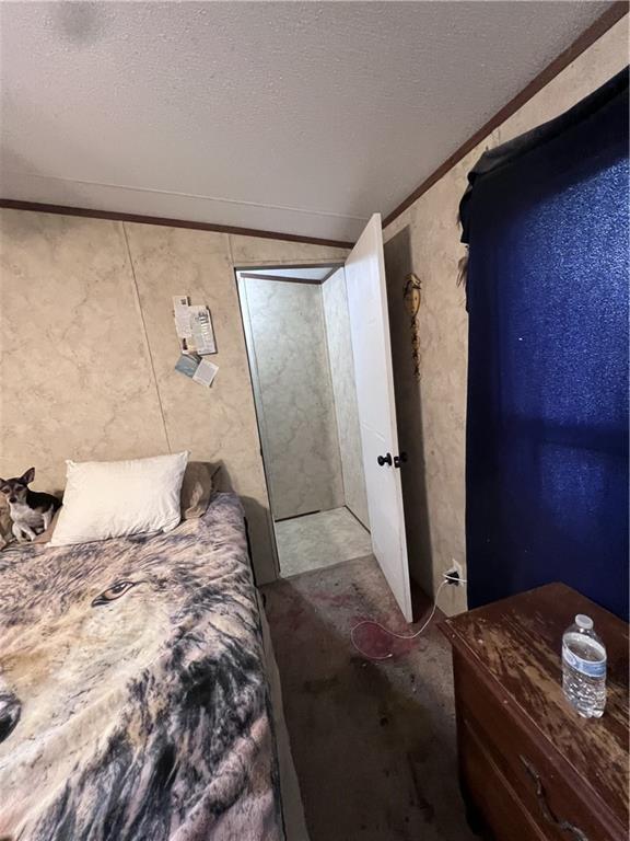 bedroom with ornamental molding and a textured ceiling