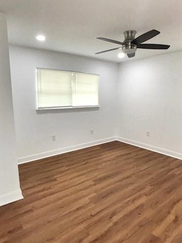 spare room featuring dark hardwood / wood-style flooring and ceiling fan