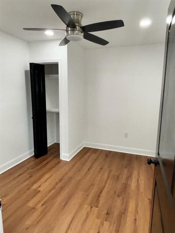 unfurnished bedroom featuring wood-type flooring, ceiling fan, and a closet