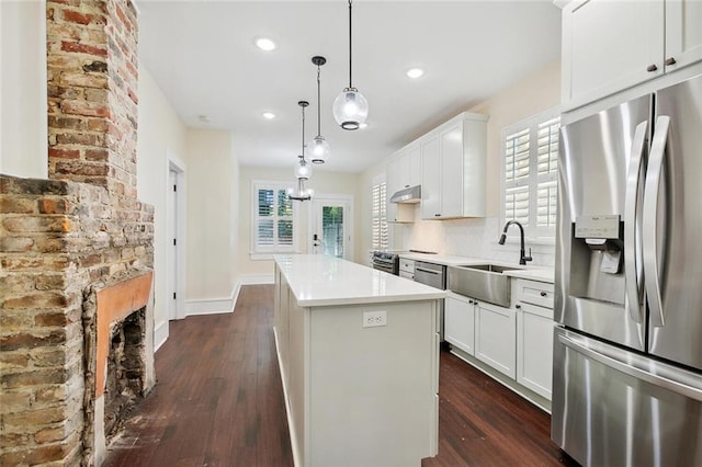 kitchen featuring a center island, light countertops, stainless steel appliances, under cabinet range hood, and a sink