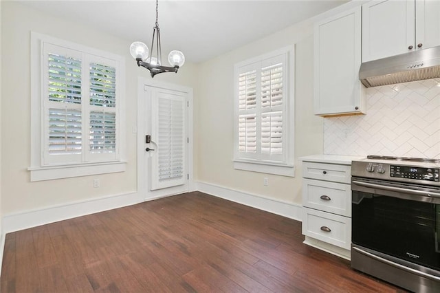 kitchen featuring a chandelier, under cabinet range hood, dark wood-style flooring, tasteful backsplash, and stainless steel range with electric stovetop