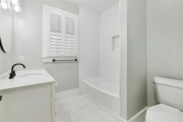 bathroom featuring marble finish floor, vanity, toilet, and baseboards