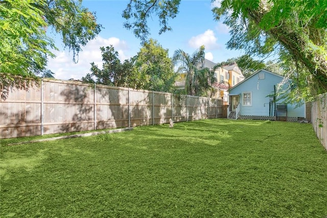 view of yard with entry steps and a fenced backyard