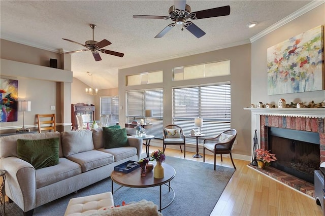 living room featuring crown molding, a fireplace, light hardwood / wood-style floors, and a textured ceiling