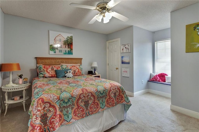 carpeted bedroom featuring ceiling fan and a textured ceiling