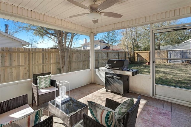 sunroom featuring ceiling fan, wooden ceiling, and a wealth of natural light