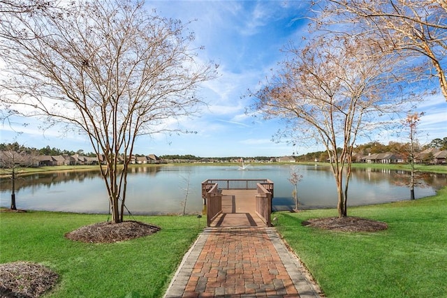 view of dock featuring a water view and a yard