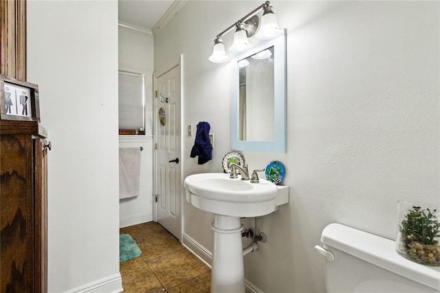 bathroom featuring tile patterned flooring, crown molding, and toilet