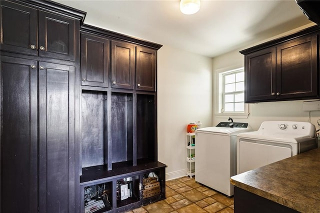 clothes washing area featuring cabinets and separate washer and dryer