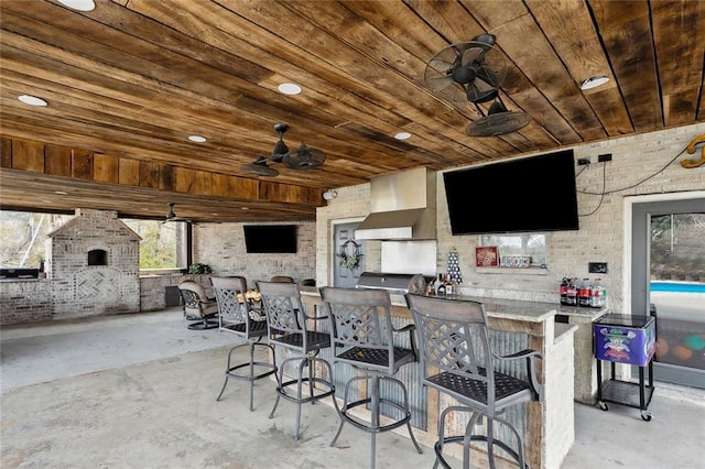 view of patio featuring area for grilling, ceiling fan, and a bar