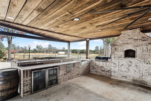 view of patio / terrace with an outdoor kitchen, a grill, a fireplace, and sink