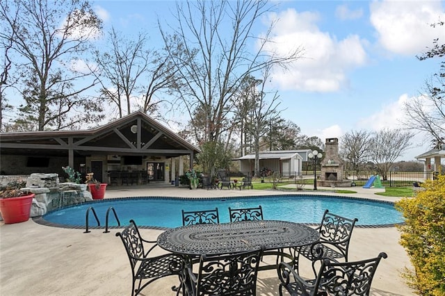 view of swimming pool featuring an outdoor bar, a patio, and an outdoor fireplace