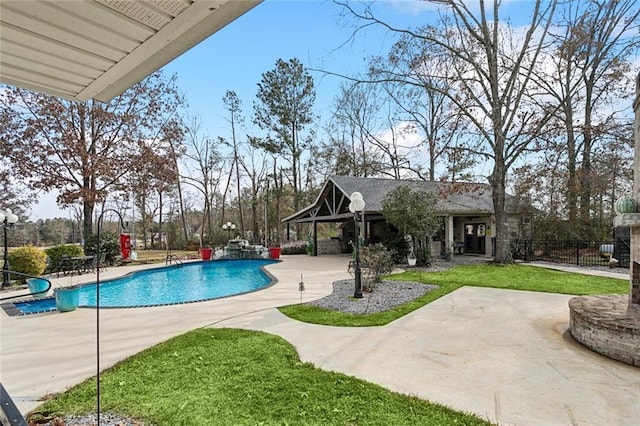 view of swimming pool featuring a patio, an outdoor structure, and a yard