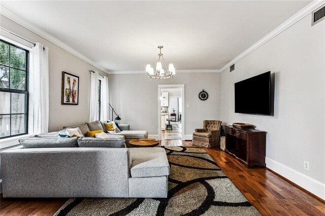 living room with ornamental molding, dark hardwood / wood-style floors, and a chandelier