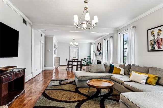 living room featuring dark hardwood / wood-style flooring, ornamental molding, and a chandelier