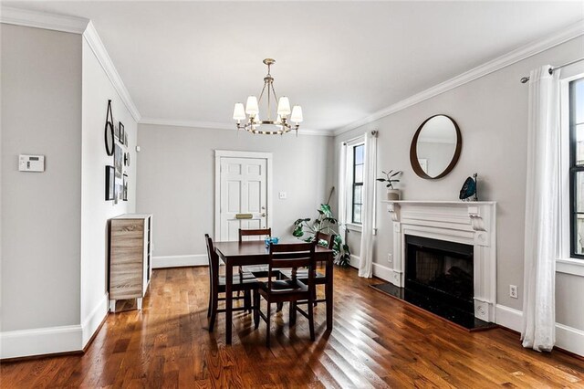 dining room with crown molding, plenty of natural light, dark wood-type flooring, and a notable chandelier