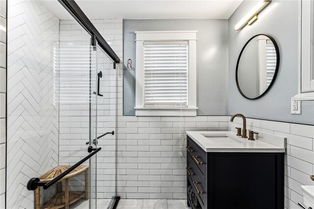 bathroom featuring vanity, an enclosed shower, and tile walls