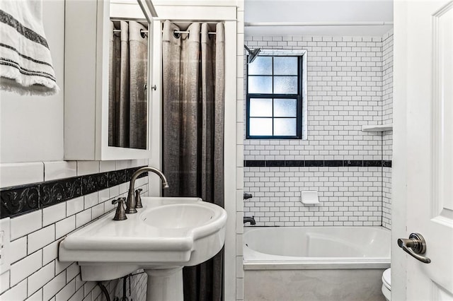 full bathroom with tiled shower / bath, sink, toilet, and decorative backsplash