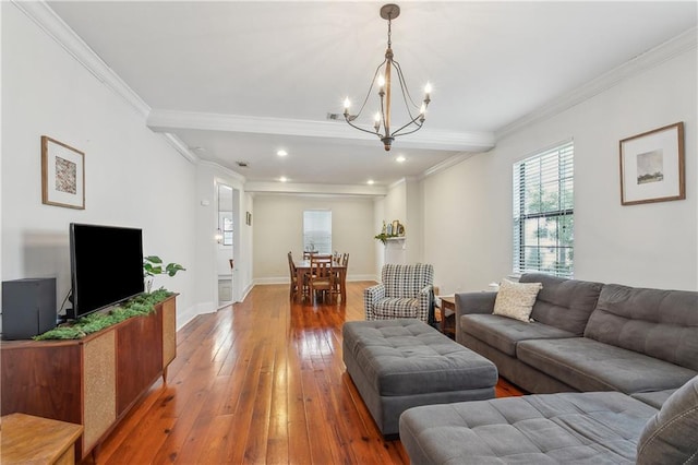 living room featuring ornamental molding, hardwood / wood-style floors, and a notable chandelier