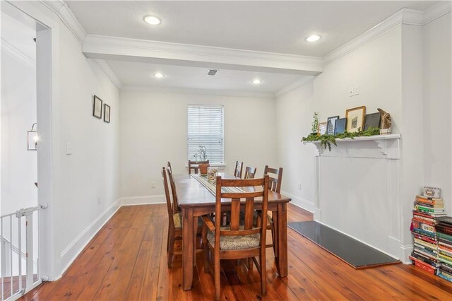 dining area with hardwood / wood-style flooring and ornamental molding