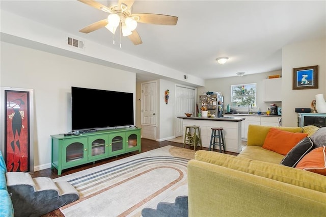 living room with ceiling fan, sink, and hardwood / wood-style floors