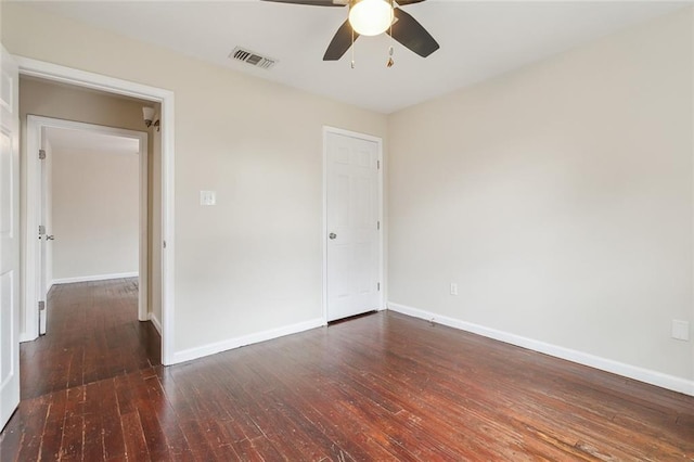 empty room with dark wood-type flooring and ceiling fan