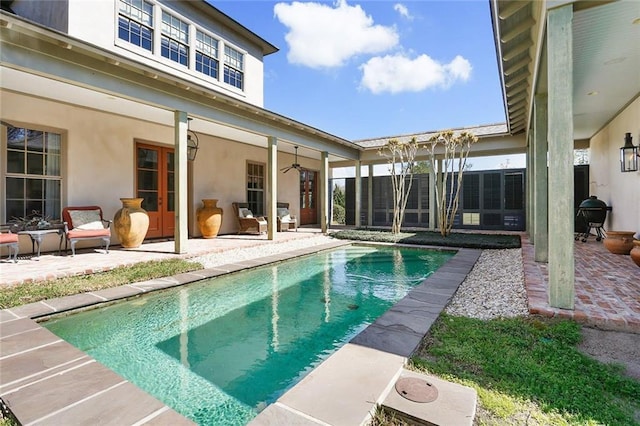 view of swimming pool featuring ceiling fan and a patio area