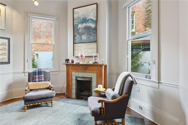 sitting room featuring a tiled fireplace and hardwood / wood-style flooring