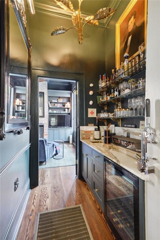 bar with wood-type flooring and wine cooler