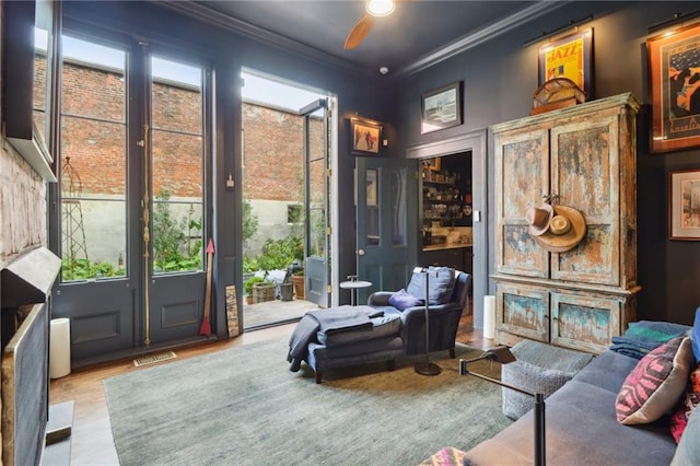 living area featuring ornamental molding, light hardwood / wood-style flooring, and plenty of natural light